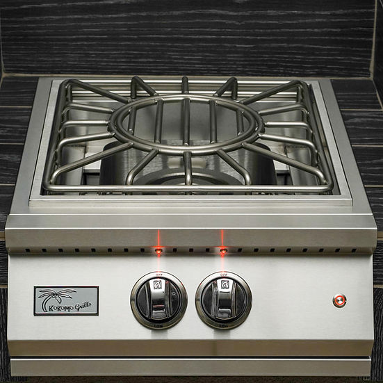 Stainless steel gas cooktop with two knobs on a tiled wall background