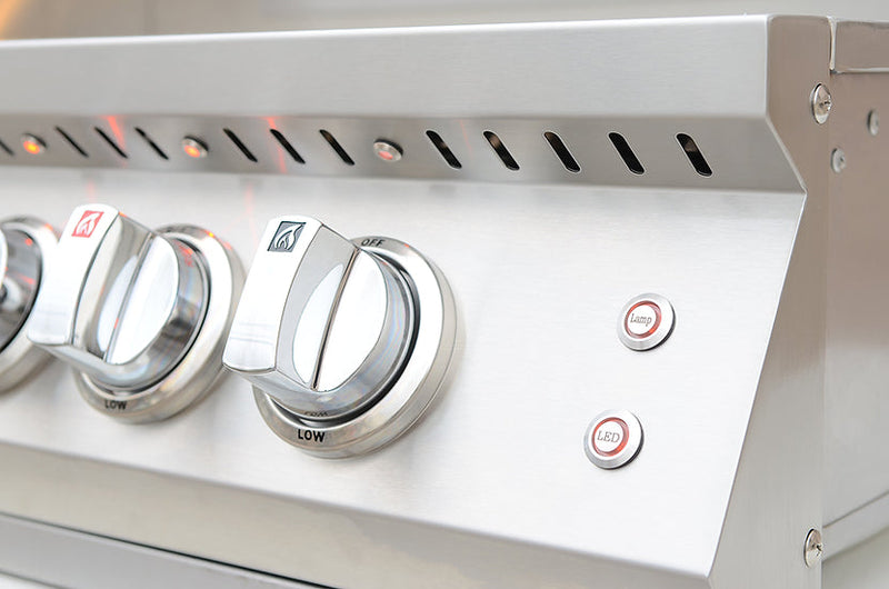Close-up of a gas grill with control knobs and igniter button.