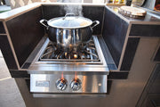 Stainless steel pot on a gas stove with steam rising, set against a modern kitchen backdrop.