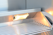 Stainless steel oven interior with glowing light and metal racks.