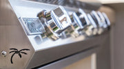Close-up of a metallic appliance with control knobs and a palm tree logo.