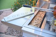 Grill with wood chips and a 'Kokomo' branded stone on a patio