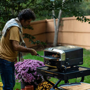 Collapsible outdoor cooking cart fully set up on backyard patio