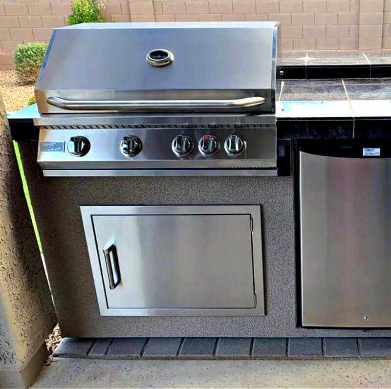 Stainless steel grill and outdoor kitchen cabinets on a patio