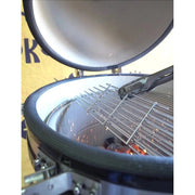 Close-up of a grill with a lid open, showing flames and coals inside.