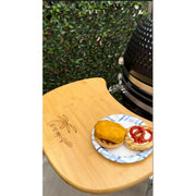 Wooden cutting board with a plate of food on a grill